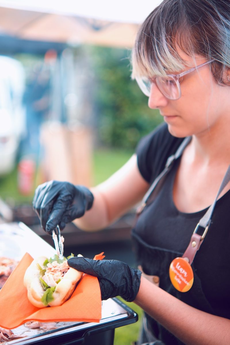 Ein Teammitglied belegt beim Catering-Einsatz ein Baguette
